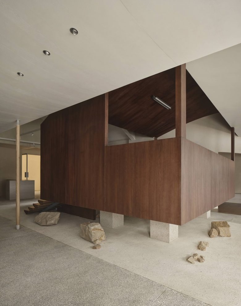 Боковой вид деревянного объема на опорах в пространстве Moment Boutique Store