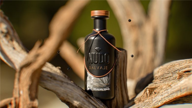 Бутылка мескаля среди веток с декоративными элементами Nudo Salvaje Mezcal