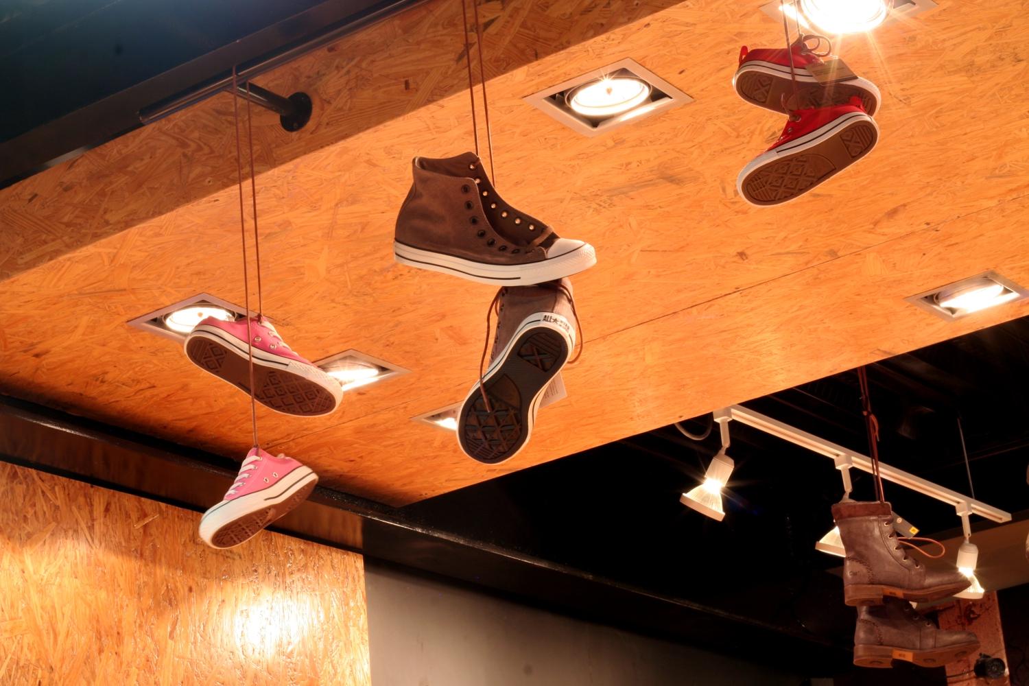 Стильные кеды подвешены на шнурках в торговом центре GUICHO