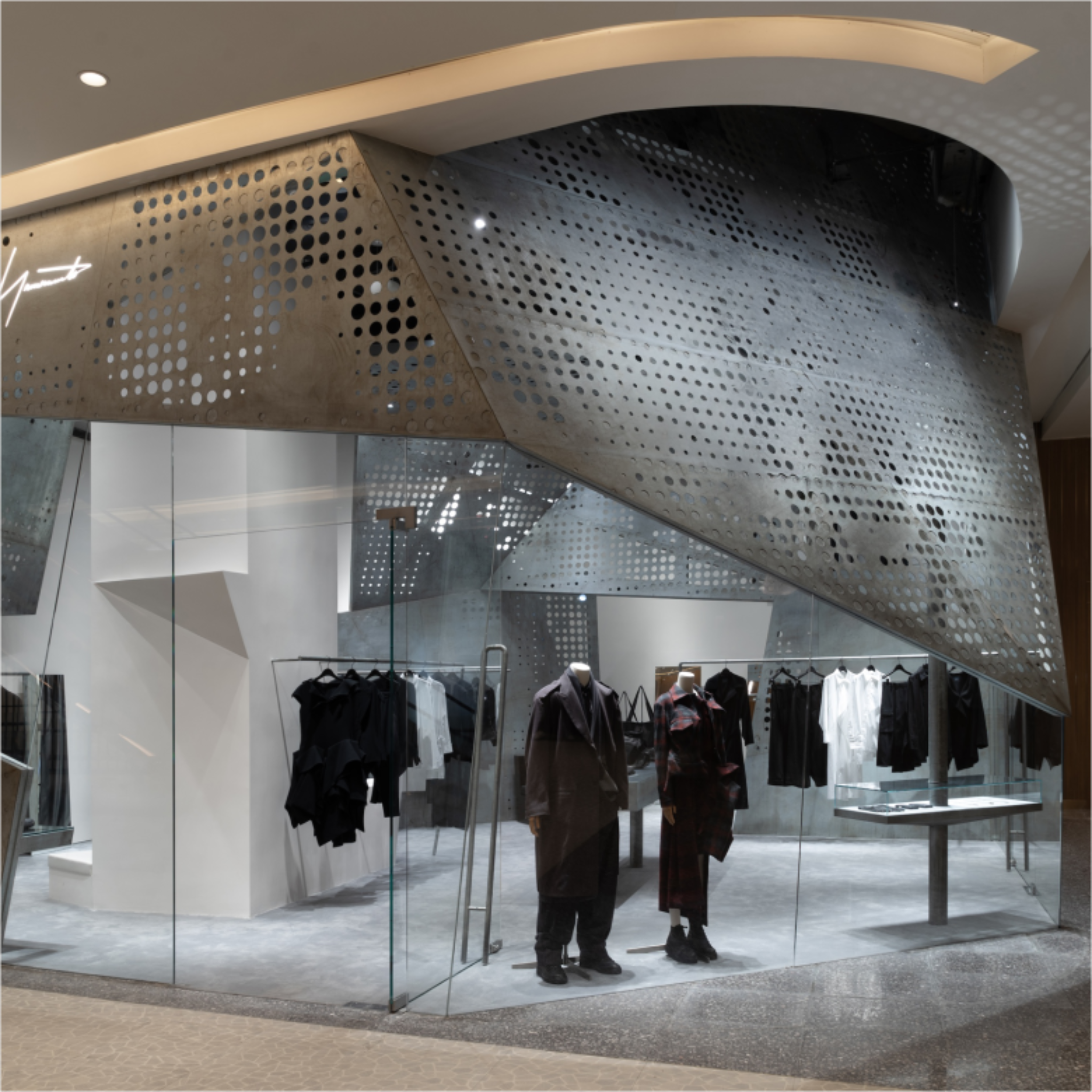Деталь фасада с перфорированным металлом и манекенами Yohji Yamamoto store