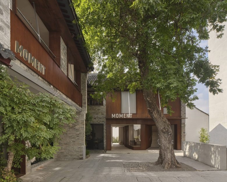 Двор с фасадом бутика и деревьями Moment Boutique Store