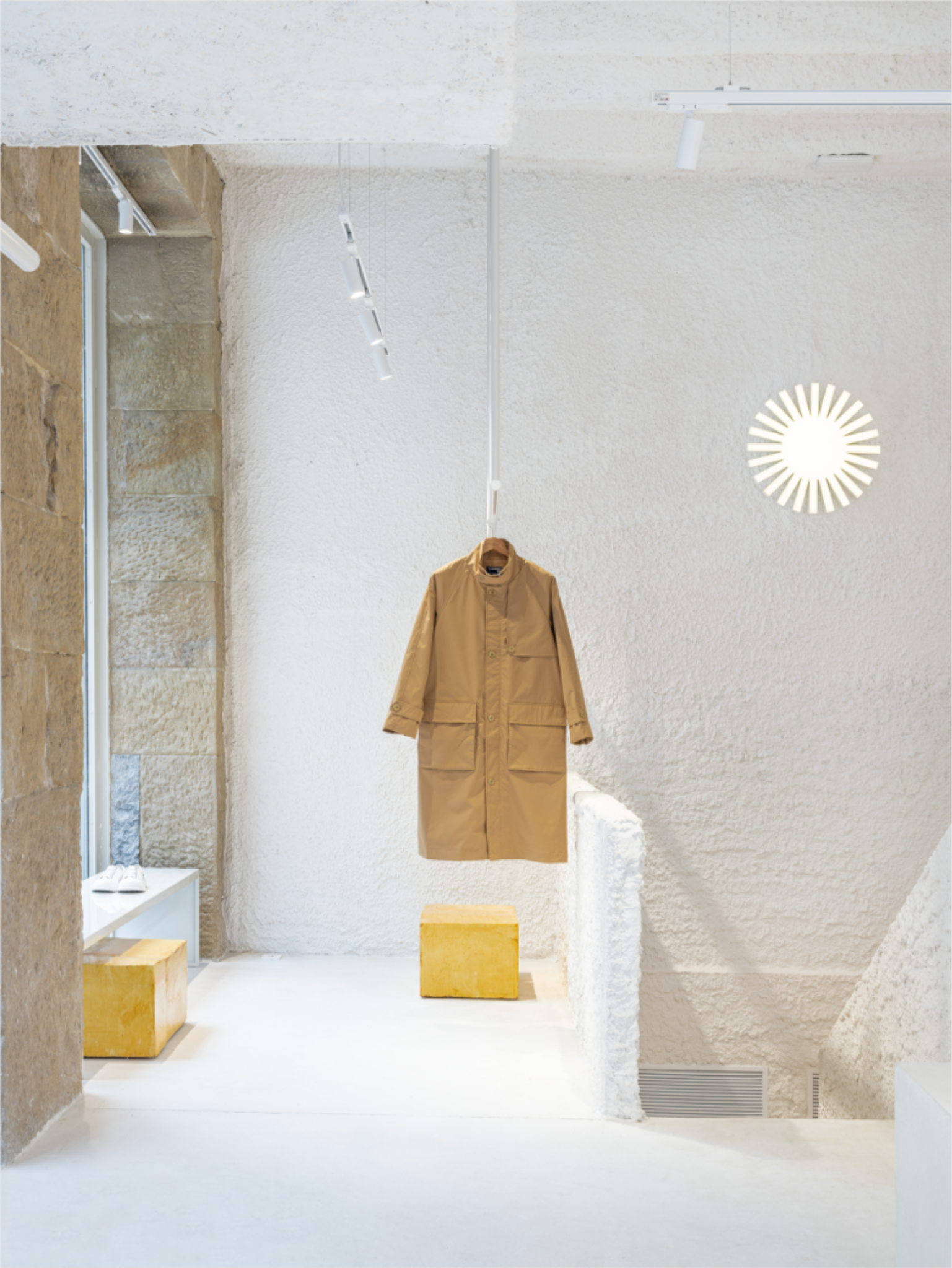 Экспозиция магазина бежевый плащ на подвесе Thinking MU Store