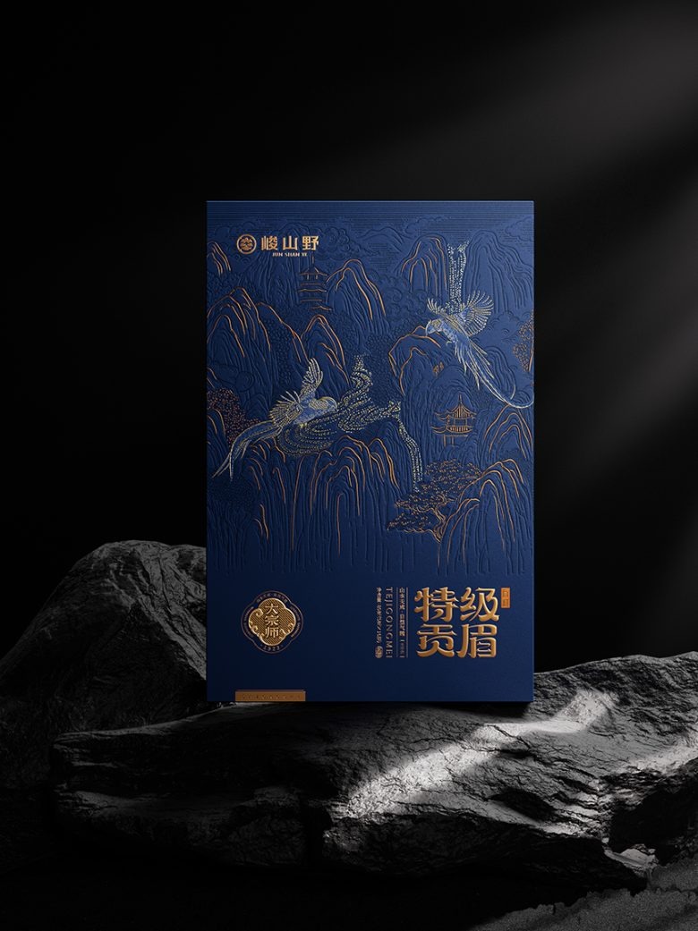 Фронтальный вид синей упаковки чая с орнаментом гор и птиц Junshanye x Gugo Brand