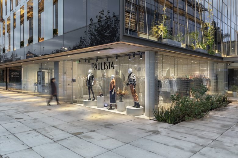 Интерьер бутика с обувной витриной и рейлами с одеждой Paulista Store