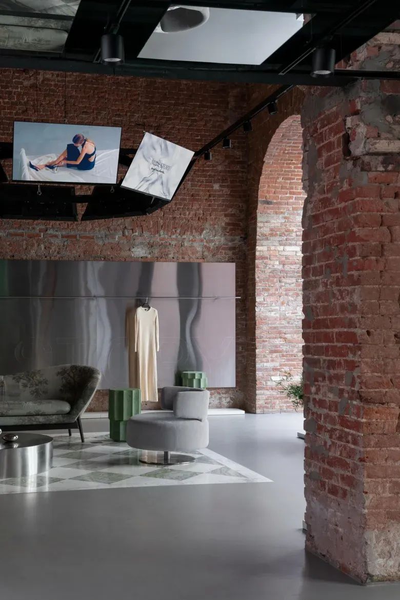 Интерьер магазина с арками и одеждой на стене NUDE STORY store