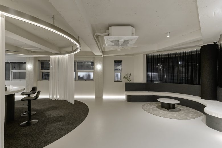 Интерьер шоурума с изогнутым диваном и зоной отдыха Self Maker Showroom