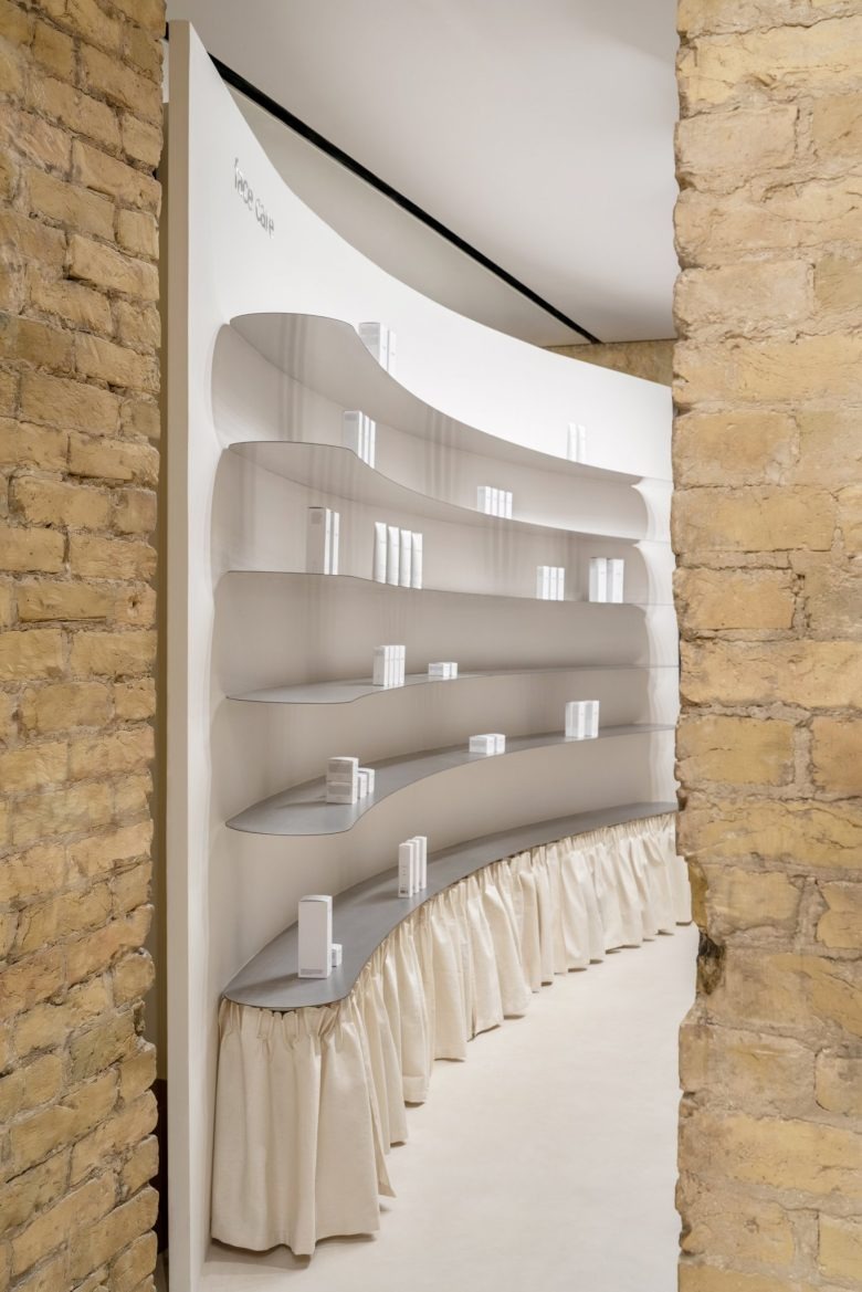 Изогнутая витрина с косметикой между стенами PLEKA Professional Cosmetics Showroom