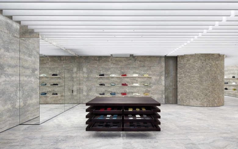 Минималистичный интерьер магазина с центральным столом и полками Jil Sander flagship store