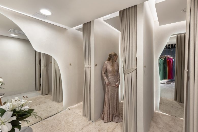 Общий вид магазина одежды с витринами и красным диваном Paulista Store