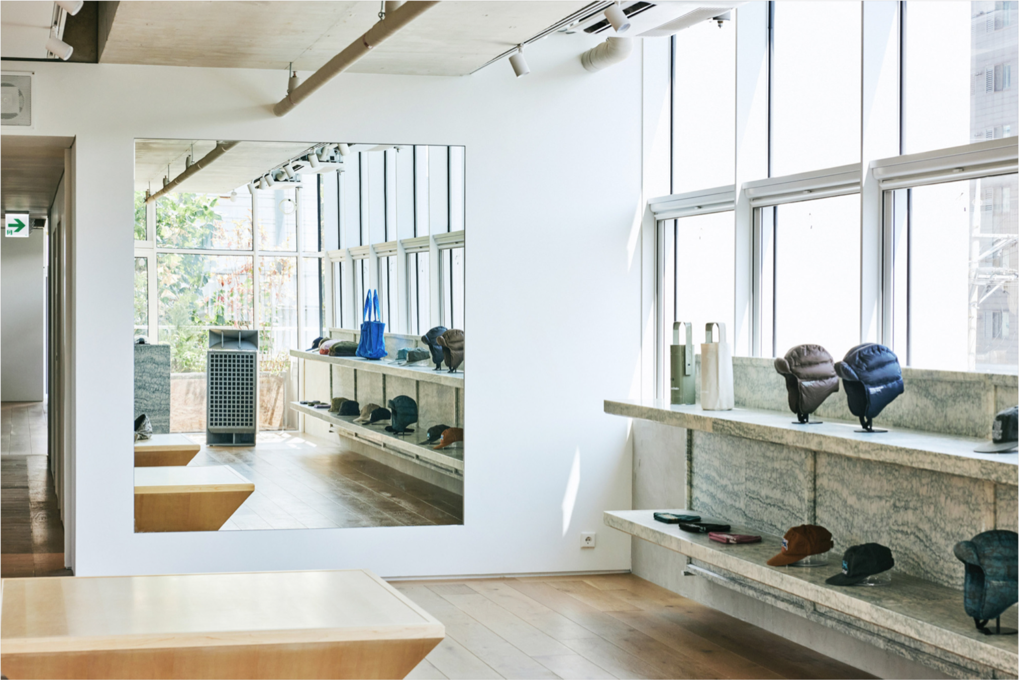 Одежда на подвесной рейке в минималистичном интерьере Thisisneverthat store