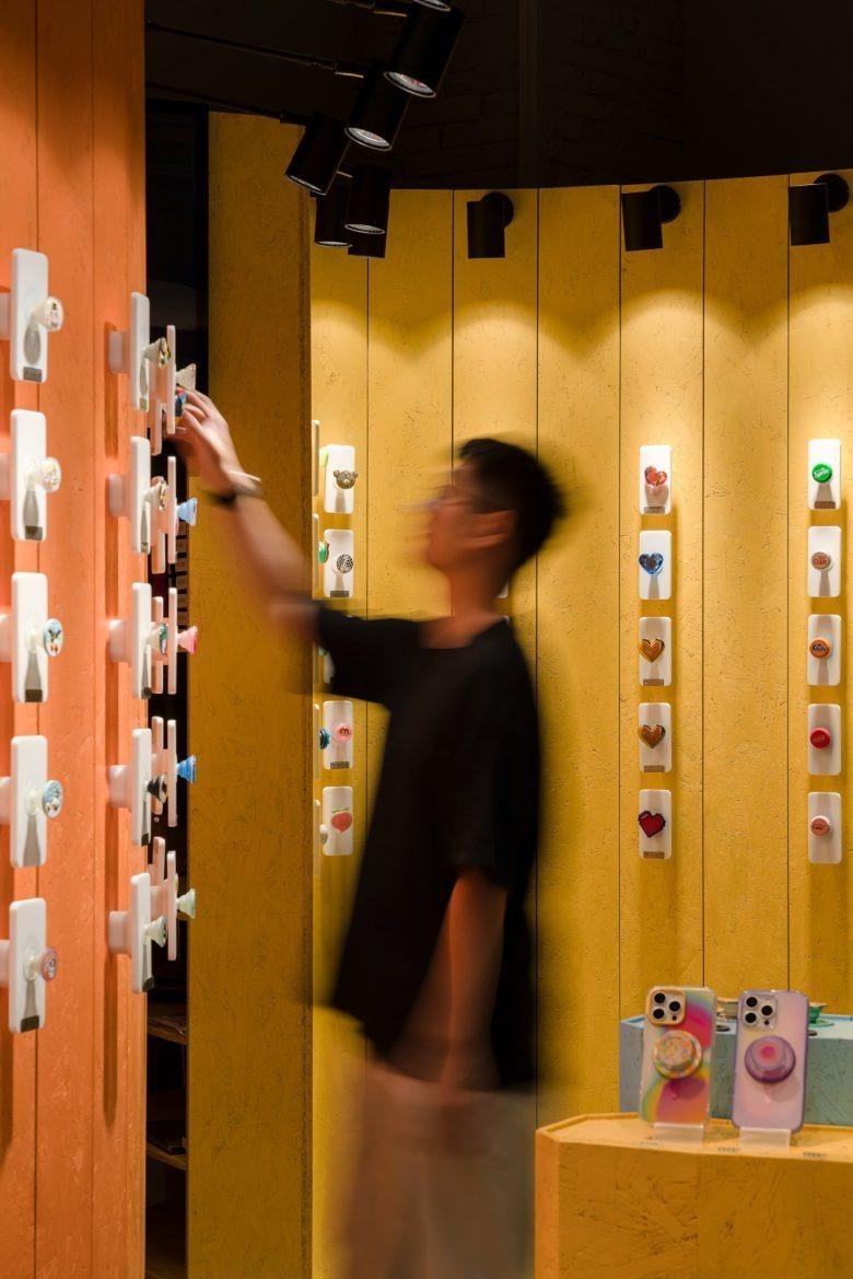 Покупатель рассматривает держатели для телефонов POPSOCKETS Pop up Store