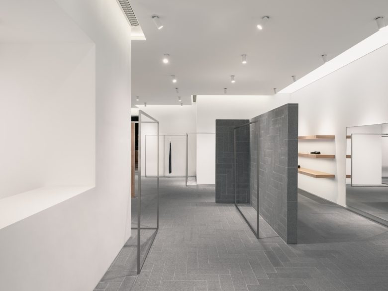 Проход с серыми стенами и витринами A SURNAME store