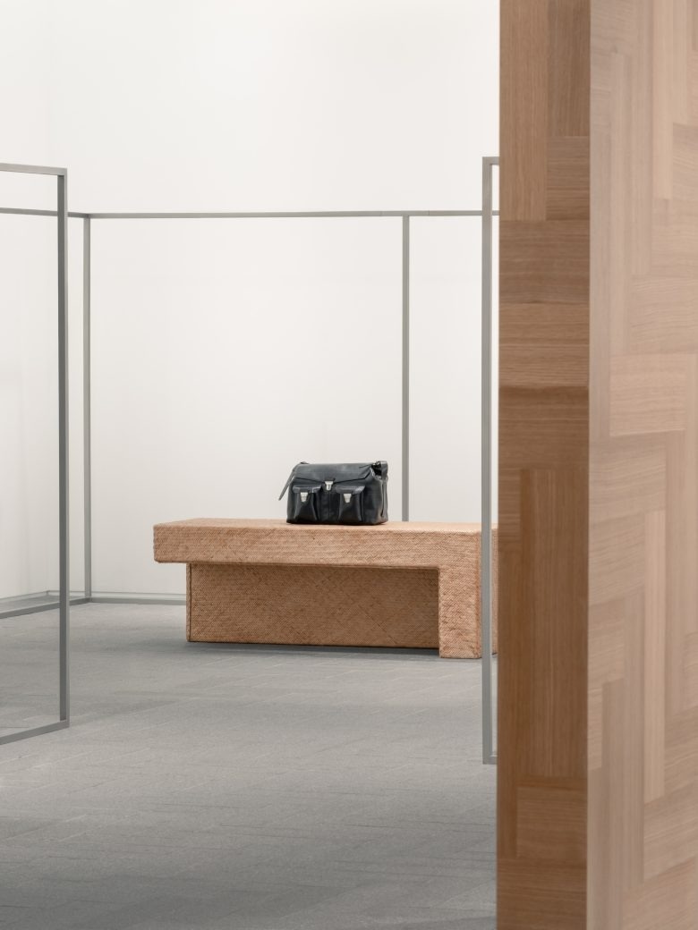 Скамья с сумкой в центре зала A SURNAME store