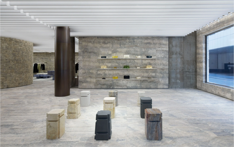 Торговый зал с каменными табуретами и витринными полками Jil Sander flagship store