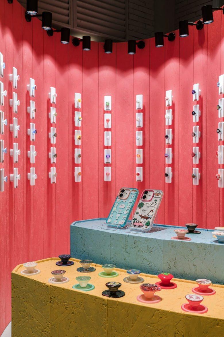 Витрина с чехлами и держателями на красном фоне POPSOCKETS Pop up Store