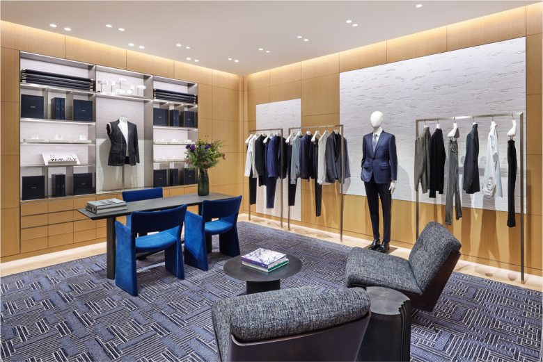Зона мужской одежды с костюмами и столом Dior store