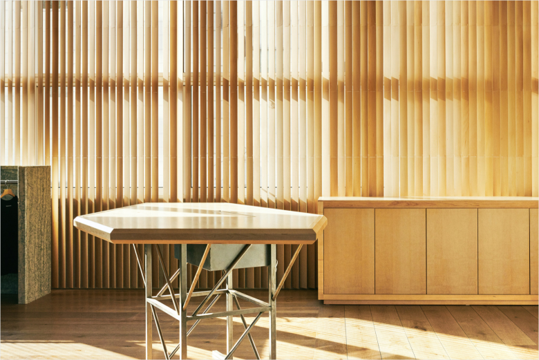 Зона с деревянной стеной и столом у окна Thisisneverthat store