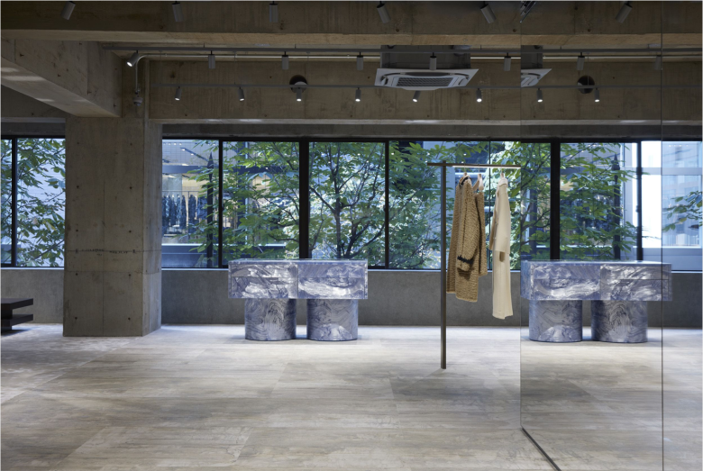 Зона с одеждой и мраморными витринами у окна Jil Sander flagship store