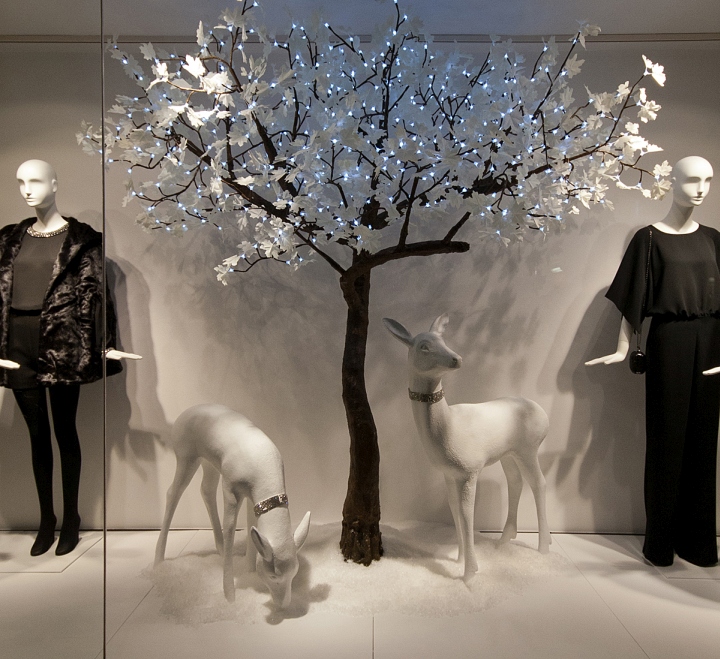 Декоративное дерево с подсветкой в дизайне витрины бутика одежды