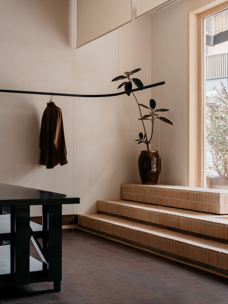 прилавок лестница Lemaire boutique у окна и вешалка на стене